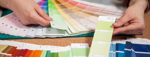 close up image of color cards on a desk with a woman going through them